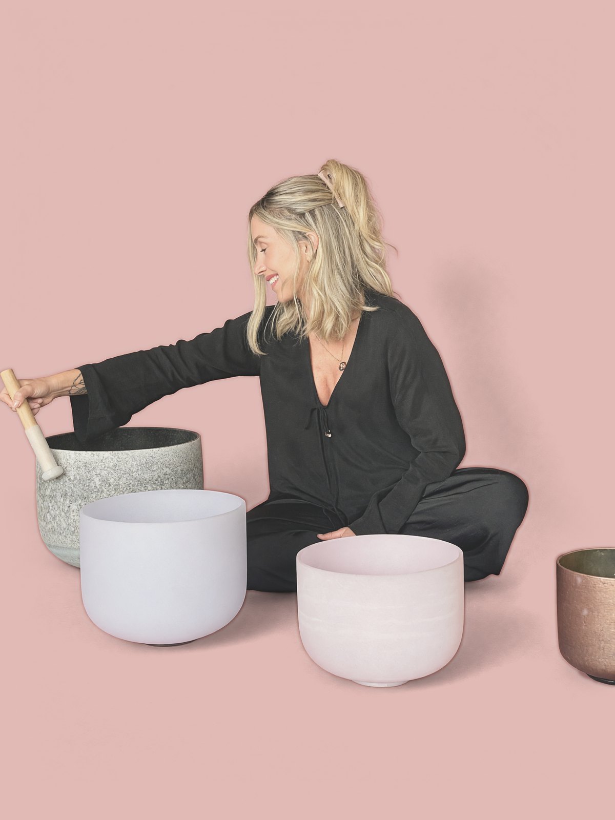 Paris smiling as she plays a set of crystal singing bowls